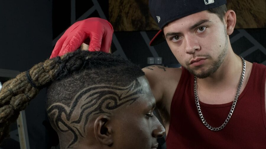 Shaun Fade cutting a freehand tribal design into a client's scalp